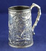 An early 20th century Chinese silver mug, decorated with birds amongst bamboo, with faux bamboo