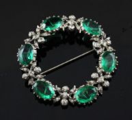 An early 20th century silver and paste open circular brooch, set with green and colourless paste,