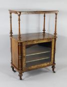 A Victorian walnut whatnot cabinet, the base with single glazed door, on turned legs and castor