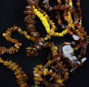 Four assorted single strand yellow ambers bead necklaces, with freeform or oval beads together