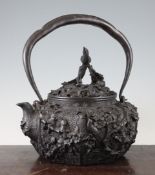 A large Japanese iron kettle, Meiji period, cast in high relief with birds amid flowers on a