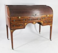 A George III mahogany and rosewood crossbanded roll top desk, the tambour shutter revealing a