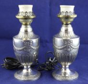 A pair of Victorian silver mounted table lamps, of vase form, embossed with ribbons and swags,