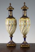 A pair of Sevres style gilt metal mounted porcelain vases, each with wrythen fluted oviform