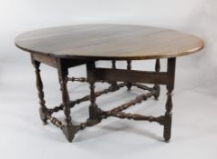 A large 18th century oval oak gate leg table, with turned baluster legs and stretchers, 5ft 9in.