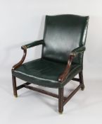 A George III style mahogany Gainsborough chair, with scrolling arms and moulded legs, with green