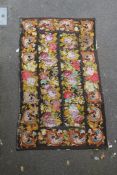 A French? woolwork panel, decorated with polychrome rows of flowers, on a brown ground, 9ft 4in by
