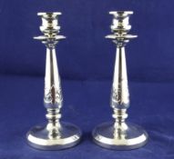 A pair of George V silver candlesticks, of tapering form, with card cut decorated stems, on circular