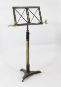 A Regency black lacquer and parcel gilt adjustable music stand, with folding brass candle sconces