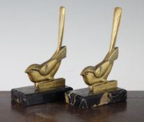 A pair of French Art Deco gilt metal bookends, modelled as birds, on black rectangular marble bases,