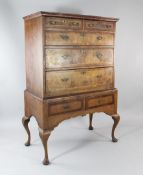 An 18th century and later feather banded walnut chest on stand, with two short over three long