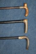 A horn handled ebony walking cane, with silver collar, together with two other similar horn