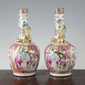 A pair of Chinese Canton decorated famille rose bottle vases, mid 19th century, typically painted