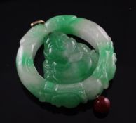 A jadeite disc pendant with centre carved as a Buddha, 2in.