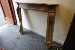 A late 19th / early 20th century stripped pine serpentine shaped fire surround, with stiff leaf
