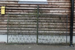 A pair of early 20th century wrought iron gates, with scrolling all over decoration, each gate W.4ft