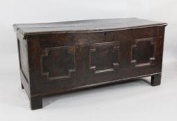 A large 17th century oak coffer, with triple panelled front on block supports, W.4ft 8in.