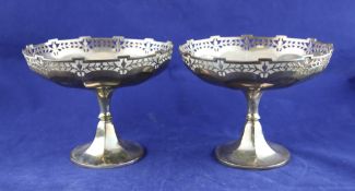 A pair George V silver pedestal fruit stands, of panelled circular form, with pierced foliate rim,