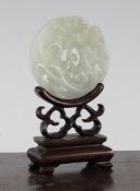 A Chinese pale celadon jade `chi-dragon` bi disc, 18th / 19th century, carved in high relief with
