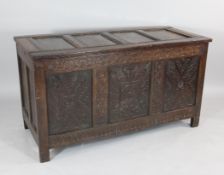 An 18th century oak coffer, three panelled front, with geometric carving and floral motifs, W.4ft