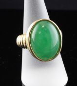 A modern gold and jadeite dress ring, with oval cabochon set stone and ribbed shank, size P.