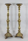 A pair of 19th century French carved and gilt torcheres, with circular tops on baluster columns