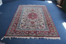 A Kashan rug, with central foliate medallion within a filed of scrolling foliage, on an ivory and