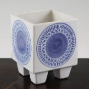 A Troika white cube vase, decorated with blue medallions on a white ground, on four square tapered