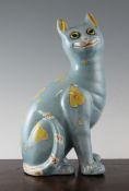 A Galle style turquoise glazed pottery seated cat, with glass set eyes and decorated with yellow