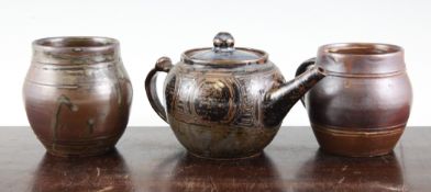 An Abuja stoneware teapot and cover and two barrel shaped mugs, early 1960`s, the globular teapot