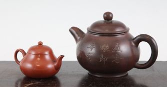 Two Chinese Yixing pottery teapots, the first of pear shape incised with calligraphic inscriptions