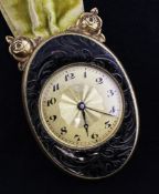 A gilt metal and enamelled Juvenia timepiece, of oval form with Arabic dial, suspended from a