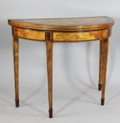 An early 19th century demi lune satinwood and rosewood crossbanded folding card table, with tapering