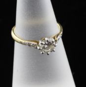 An 18ct gold and diamond solitaire ring, with diamond set shoulders, size K. Starting Price: £240