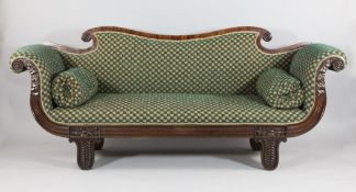 An early 19th century mahogany scroll end settee, with green pattern fabric, carved show frame and
