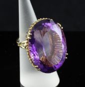 A 20th century 18ct gold and solitaire amethyst dress ring, the large oval cut stone in a deep