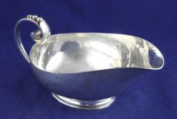 A stylish 1930`s silver sauceboat by Robert Edgar Stone, with planished decoration and scroll handle