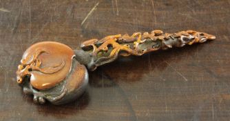 A Chinese bone ruyi sceptre, the russet stained sceptre carved with peaches and pierced branches,