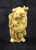 A Japanese ivory figure of Hotei, in standing pose with a fan in his left hand, two character