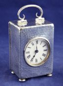 An Edwardian silver cased travelling timepiece, of rectangular form, with hammered decoration and