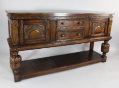A Jacobean style carved oak sideboard, with two central doors, cupboard doors, cup and cover