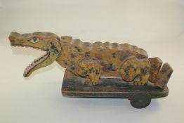 A child`s painted wood pull-a-long alligator, with opening mouth and moving tail, 20in. Starting