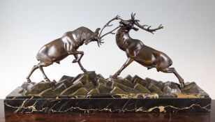 Irene Rochard. An Art Deco bronze figure group modelled as fighting stags, on a rectangular marble