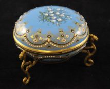 A 19th century French gilt brass and blue enamel circular trinket box, the lid decorated with