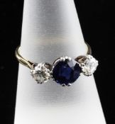 An 18ct gold, three stone diamond and sapphire ring, with central sapphire flanked by diamonds, size