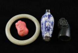 Three Chinese jades and two snuff bottles, the first a white and russet jade pebble carving,