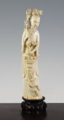 A Chinese ivory standing figure of He Xiangu, early 20th century, holding a sprig of lotus and
