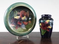 A Moorcroft `Orchid` small shallow bowl and a small ovoid vase, c.1960; the former on blue to