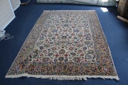 A Tabriz carpet, with field of scrolling foliage on an ivory ground, with three row foliate