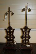 A pair of Chinese wood lamp bases, each carved as a Shou character, with adjustable height brass